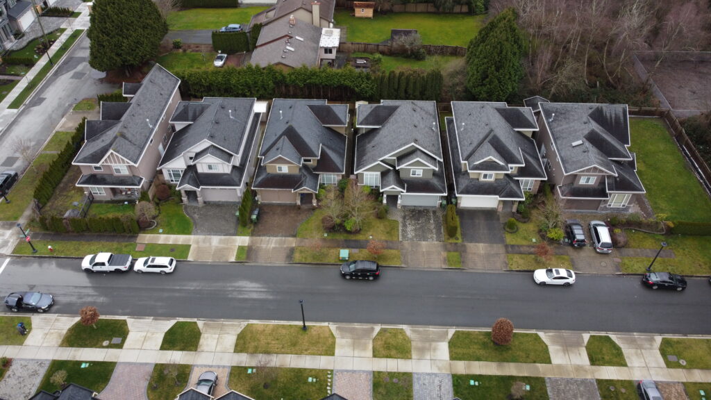 Aerial view of a suburban street on Sills Avenue with rows of similar two-story homes, parked cars, and bare trees.